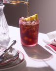 Blush tumbler with an iced drink and lemon on a dining table