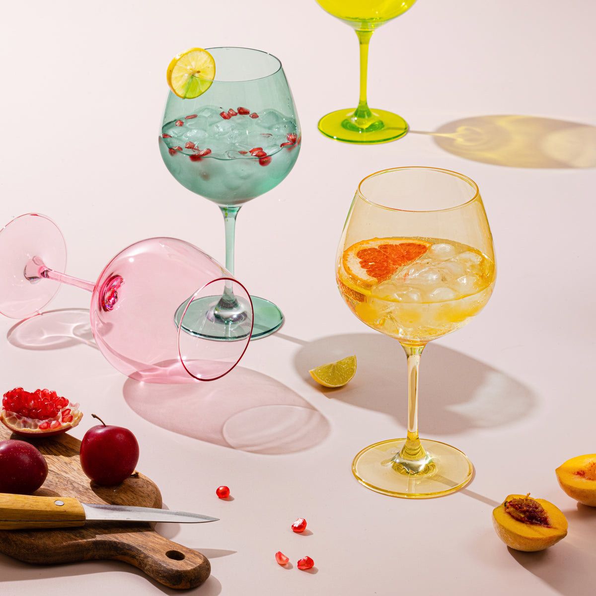 Pastel goblets with gin cocktails, pomegranate and citrus